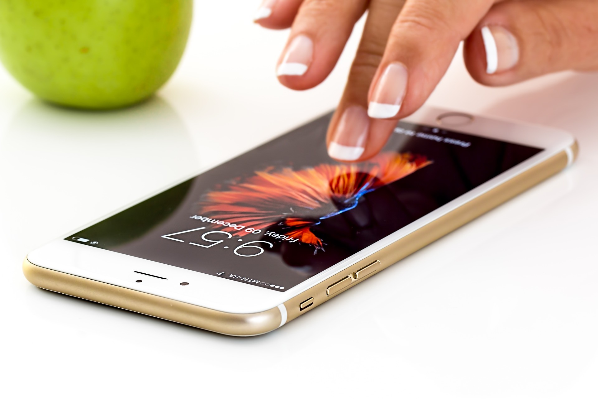 Ein Smartphone liegt am Tisch, Finger bedienen es!