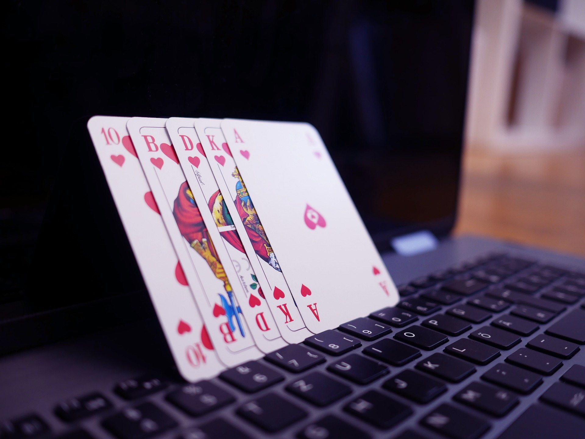 Ein Bild von vier Spielkarten, die auf einem Laptop stehen